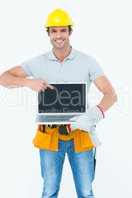 Happy carpenter holding laptop