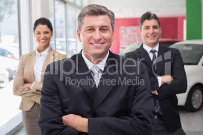 Smiling business team standing with arms crossed