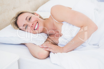 Happy blonde woman lying in bed Happy blonde woman lying in bed