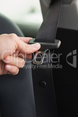 Man putting on his seat belt