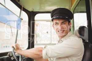 Smiling driver driving the school bus