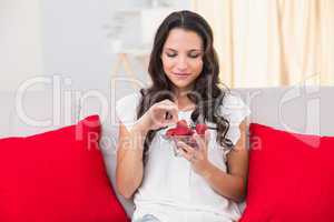 Pretty brunette eating strawberries on couch