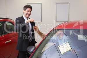 Businessman giving car key while shaking a customer hand