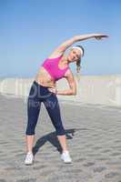 Fit blonde stretching on the pier