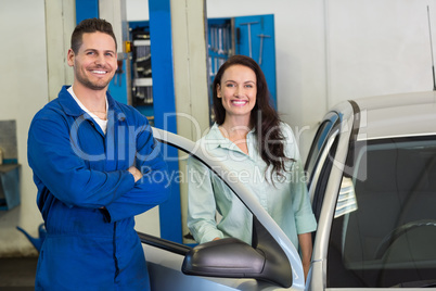 Mechanic smiling at the camera with customer