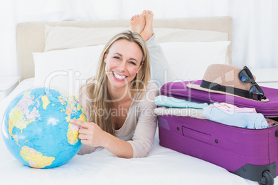 Smiling blond pointing a country on the globe