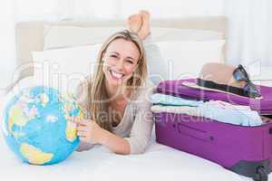 Smiling blond pointing a country on the globe