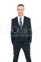 Smiling businessman in suit with hands in pocket posing