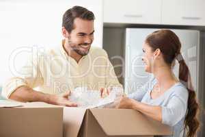 Young couple unpacking boxes in kitchen