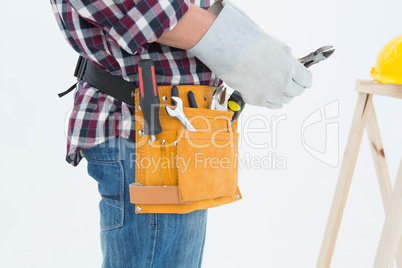 Repairman wearing glove while holding pliers