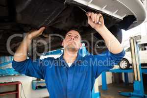 Mechanic examining under the car