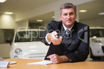 Smiling salesman giving a customer car keys