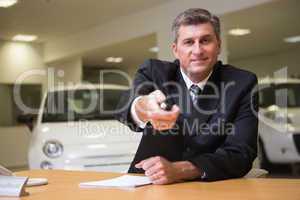 Smiling salesman giving a customer car keys