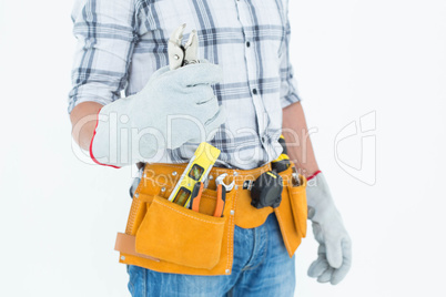 Technician with tool belt around waist holding pliers