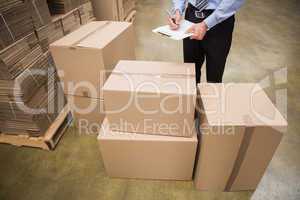 Warehouse worker checking his list on clipboard