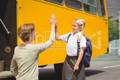 Mother with her daughter by school bus