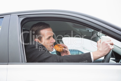 Businessman having coffee and doughnut on the phone