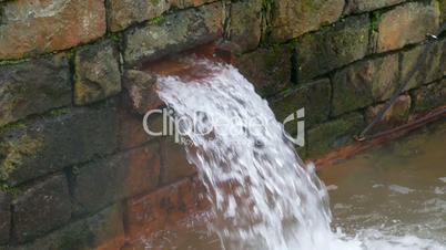 Hot Spring Water Flow from Pipe on Wall, closeup
