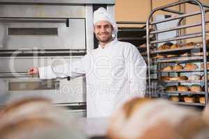 Happy baker leaning on professional oven