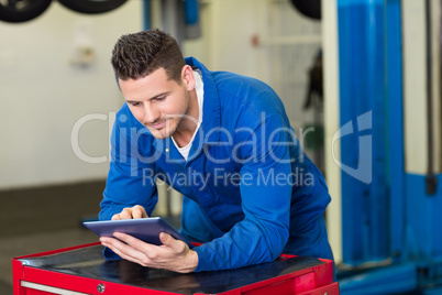 Smiling mechanic using his tablet