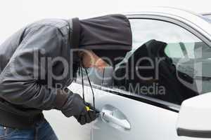 Thief breaking into car with screwdriver