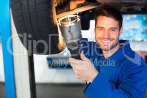 Mechanic using torch to look under car