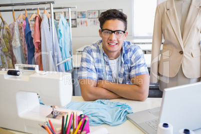 College student sitting with sewing machine and laptop