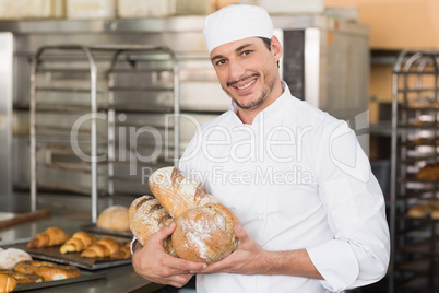 Baker holding freshly baked loaves