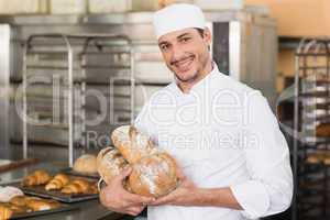 Baker holding freshly baked loaves