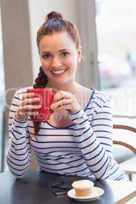 Young woman having a cupcake