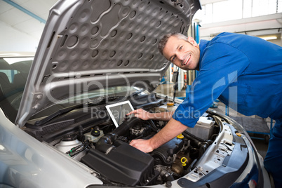 Mechanic using tablet to fix car