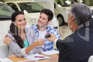 Salesman giving car keys to a couple