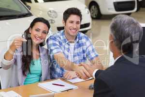 Salesman giving car keys to a couple