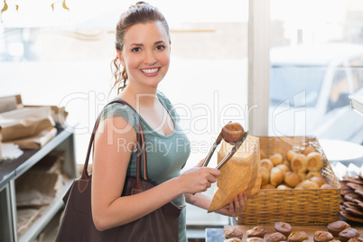 Pretty brunette picking out croissant