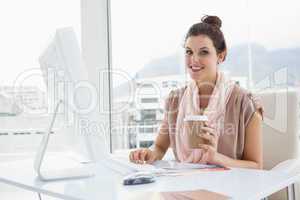 Smiling businesswoman holding paper cup of coffee
