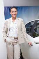 Smiling businesswoman holding a car door handles