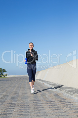 Fit blonde jogging on the pier