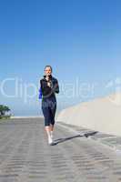 Fit blonde jogging on the pier