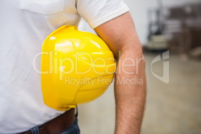 Close up of warehouse worker holding a hard hat