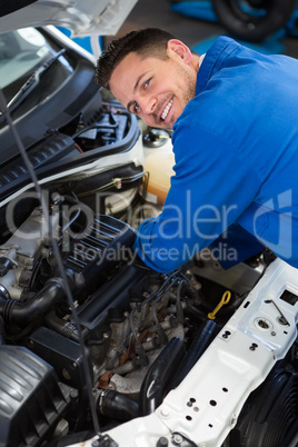 Mechanic examining under hood of car