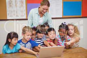 Teacher and pupils looking at laptop