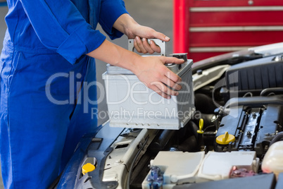 Mechanic examining under hood of car