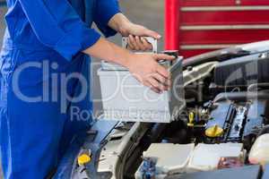 Mechanic examining under hood of car