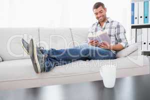 Relaxing man on a sofa with a book