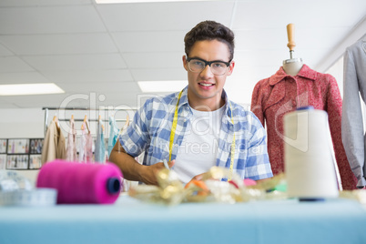 Fashion student cutting fabric with pair of scissors