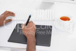 Designer using computer and digitizer with tea