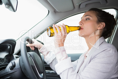 Woman drinking beer while driving