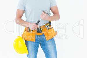 Worker holding hammer over white background