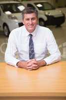 Happy businessman sitting at his desk