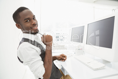 Smiling businessman sitting and holding pencil